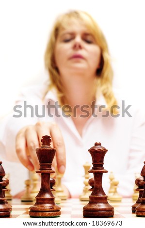 blond woman in white shirt playing a move during a chess game