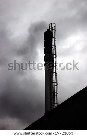chimney of an industrial plant with black smoke coming out of it