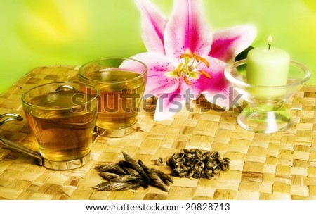 glass cups of green tea with a lily flower and candle as decoration