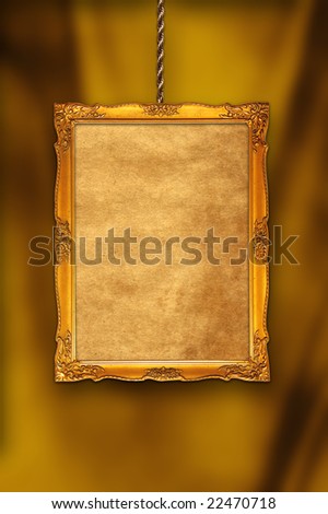 gold classical frame with a blank grunge canvas hanging by a chain against a drapery