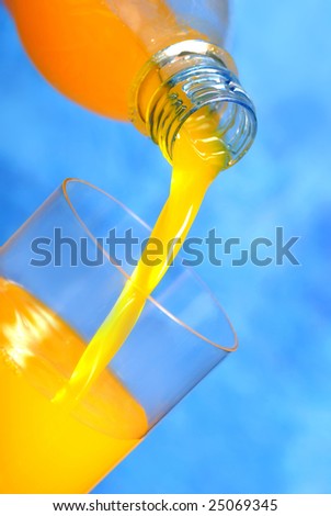 pouring a fresh glass of orange juice