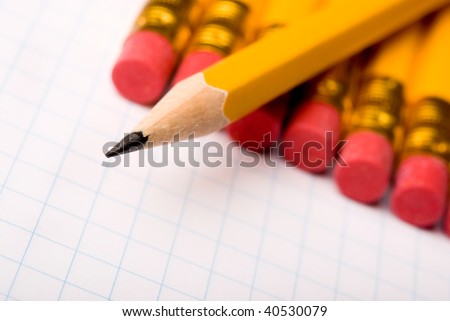 yellow pencils in a row on white paper
