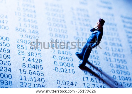 businessman figurine standing on a financial data report