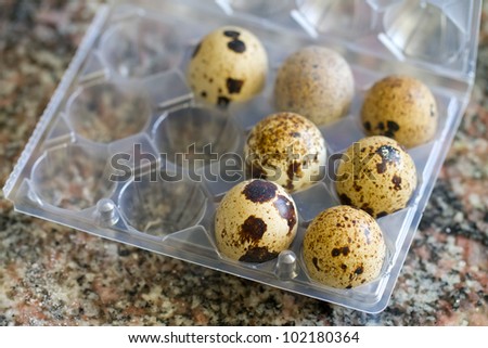 quail eggs on egg box over marble cooking top background