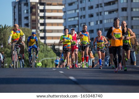 VALENCIA - NOVEMBER 17: Jose Maria Solaz Quer (number 1085) leads his UPV Team group during his participation in Valencias marathon on November 17, 2013 in Valencia, Spain