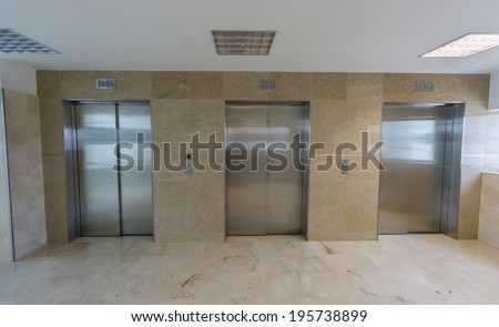 Wide angle view of three modern elevators with closed doors
