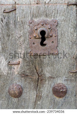 Closeup of vintage run-down wooden door and rusty iron lock