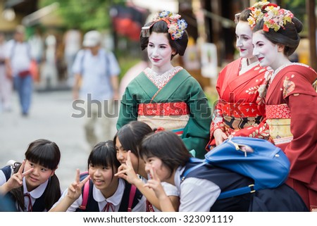 KYOTO, JAPAN - JUNE 10: Unidentified tourist women dress like a Maiko and take photo with children, Tourists usually makeup as Geishas (also known as Maiko) in Kyoto on June 10, 2015 in Japan