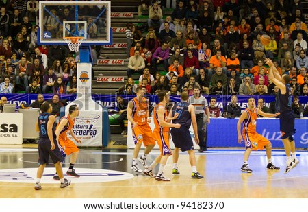 VALENCIA, SPAIN - JANUARY 28: Carlos Jimenez (blue shirt #10)  three-point shot during the league match between Valencia Basket  and Asefa Estudiantes, 85-71, on January 28, 2012, in Valencia, Spain