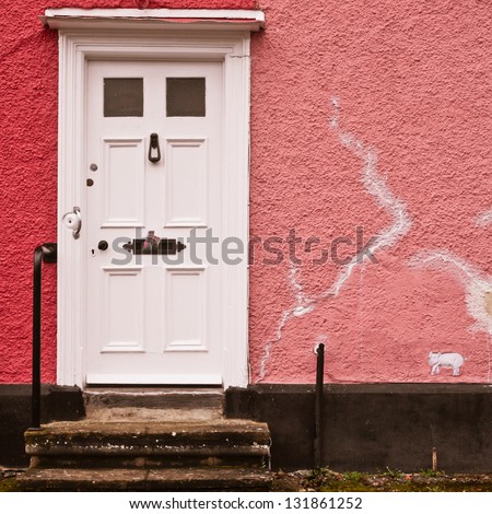 White front door in a pink wall