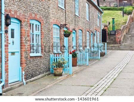 Row of stone cottages with blue doors in Aldeburgh, UK
