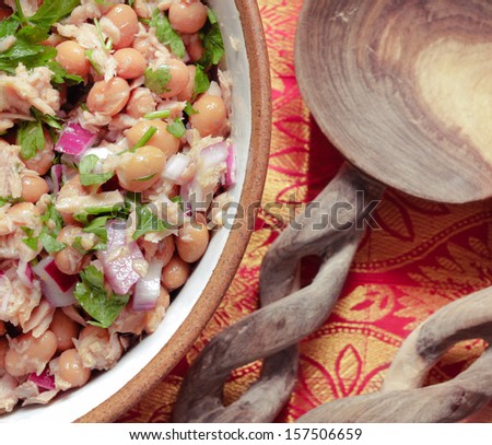 Close up of tuna and borlotti bean salad in a bowl with wooden spoons
