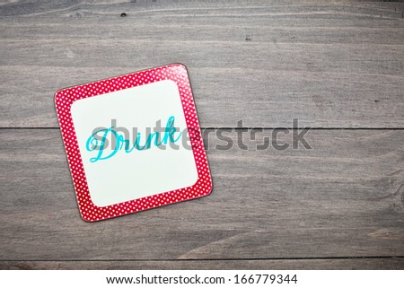 A colorful retro drink coaster on a wooden surface