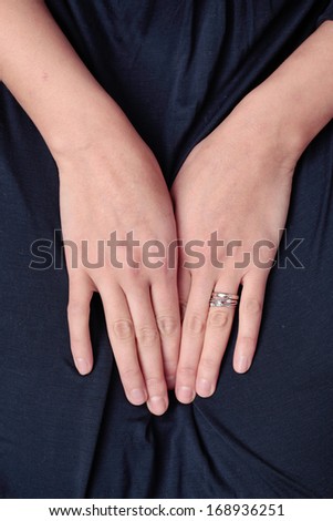 A woman\'s hands wearing engagement ring and wedding band
