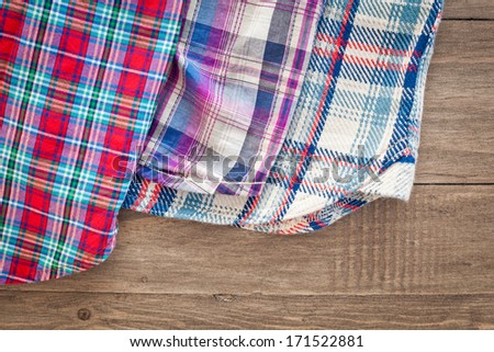 Selection of tartan cotton fabrics on a wooden surface