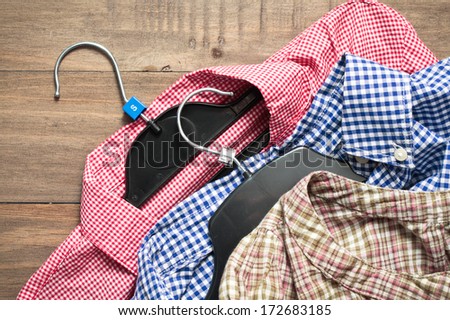 Three casual checked ladies\' shirts with hangers