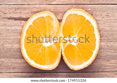 A cut open orange on a wood surface