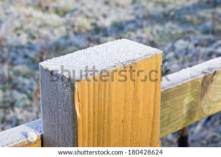 Frost on top of a wooden fence post