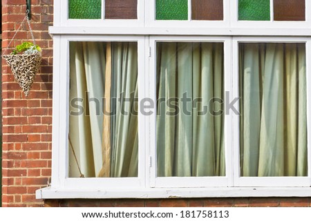 House window with closed curtains in the daytime