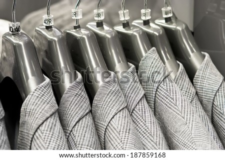 Suit jackets of various sizes hanging in a store