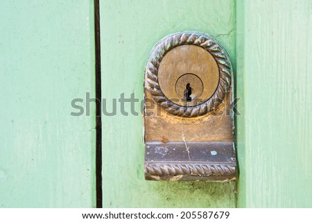 Close up of a metal lock on a green door