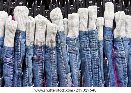 Denim jeans with elasticated waist bands hanging in a store