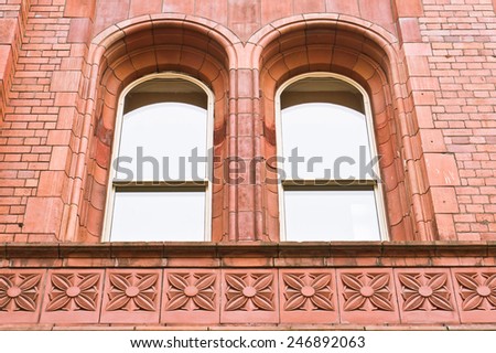 A pair of arch windows in a red brick building in Manchester, UK