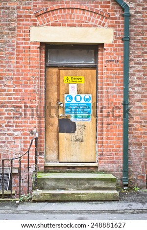 Door of a derelict building with safety signs