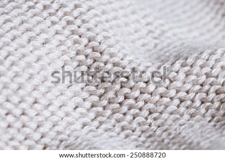 Close up of gentle creases in a piece of white wool knitwear