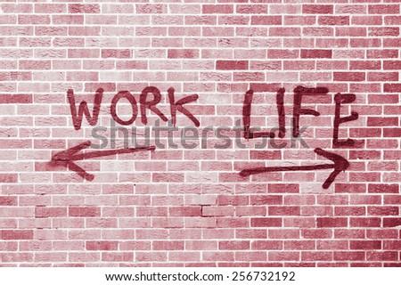 Work and life painted on a brick wall with red filter