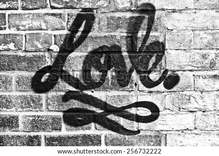Love in graffiti paint on a brick wall  in black and white
