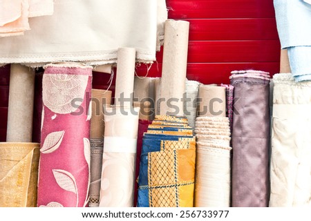 Colorful rolls of patterned fabric on sale at a market