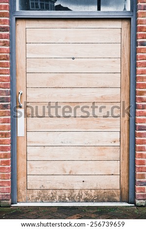 A modern wooden door in a brick building