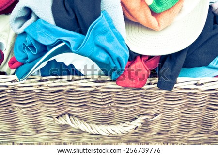 Children\'s clothes in a wicker hamper with retro filter applied