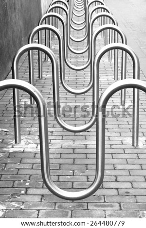Row of metal bike racks giving an abstract pattern in black and white