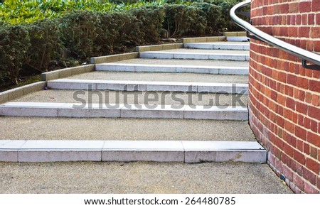 Modern stone steps in a UK town with a metal railing