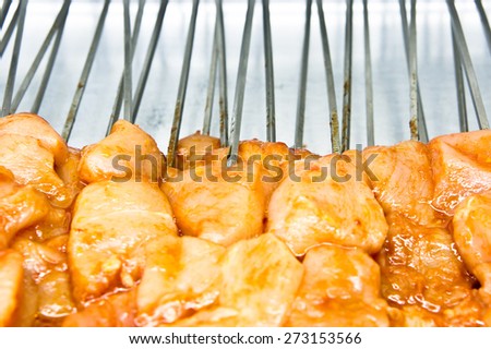 Raw chicken pieces on skewers in a kebab shop