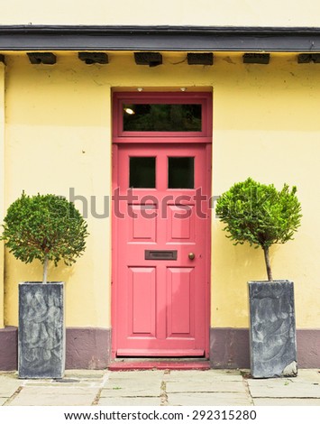 A red front door in a yellow cottage in England