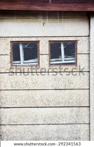 two small square windows in a stone wall