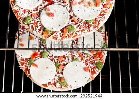Two frozen pizzas ready to be baked