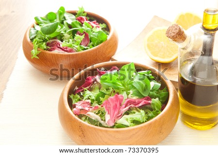 Two bowls of fresh salad with olive oil and lemon