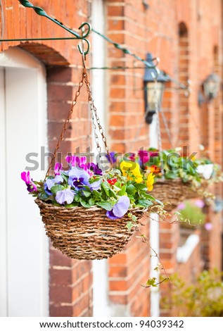 Row of hanging baskets outside red brick houses
