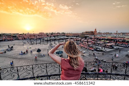 Jamaa el-Fna market Marrakech at sunset. Tourist watching the shops in the old medina.