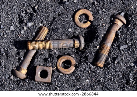rusted bolts and washers in dark fine gravel