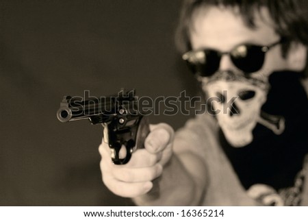 a masked man armed with a hand gun