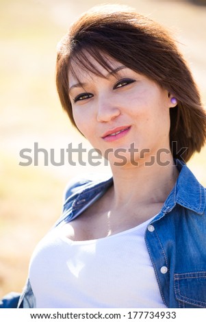 Sexy mixed race girl posing, sitting, walking, laying in a grassy field with a precast wall in Cape Town South Africa