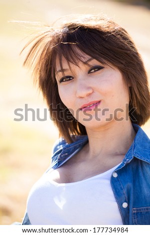 Sexy mixed race girl posing, sitting, walking, laying in a grassy field with a precast wall in Cape Town South Africa