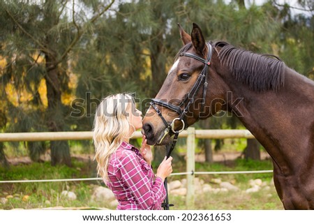 Sexy blond farm girl posing with her horse on a farm in South Africa