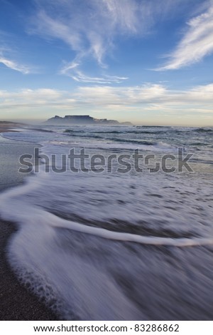 Beautiful clouds over Table Mountain in cape town south africa, on the beach with a nice surf wash