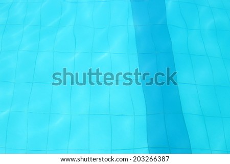 Ground of a swimming pool with water waves in the sun